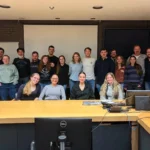 Outreach A group portrait of university researchers and students from Ribeiro Lab, including Dr. Scott Westlake, posing together in a conference room after a laboratory meeting.