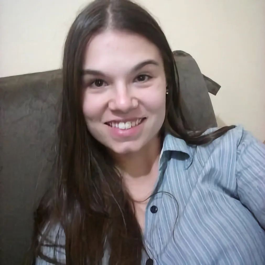 Members A portrait of a woman with long dark brown hair, smiling and wearing a blue striped button-down shirt.