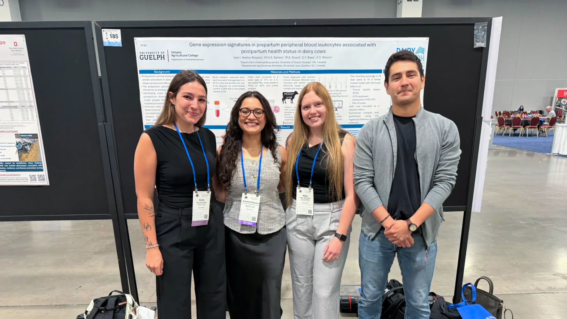 Ribeiro Lab at ADSA 2026 Wrap-Up Four researchers posing together in front of a scientific poster presentation at an academic conference hall. The research poster displays University of Guelph branding and is titled 'Gene expression signatures in prepartum peripheral blood leukocytes associated with postpartum health status in dairy cows'.